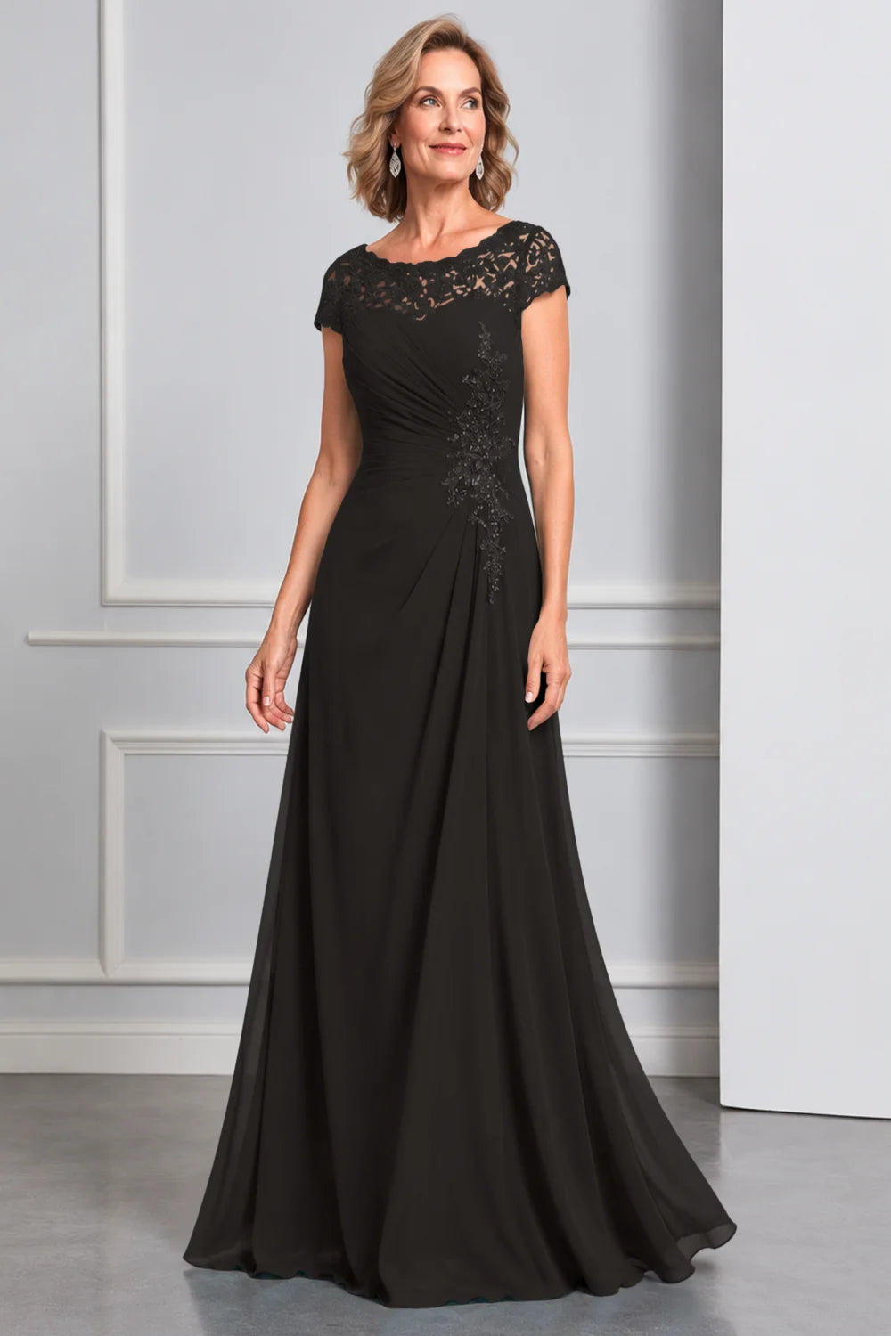Front view of a black dress with lace cap sleeves and side waist decoration.