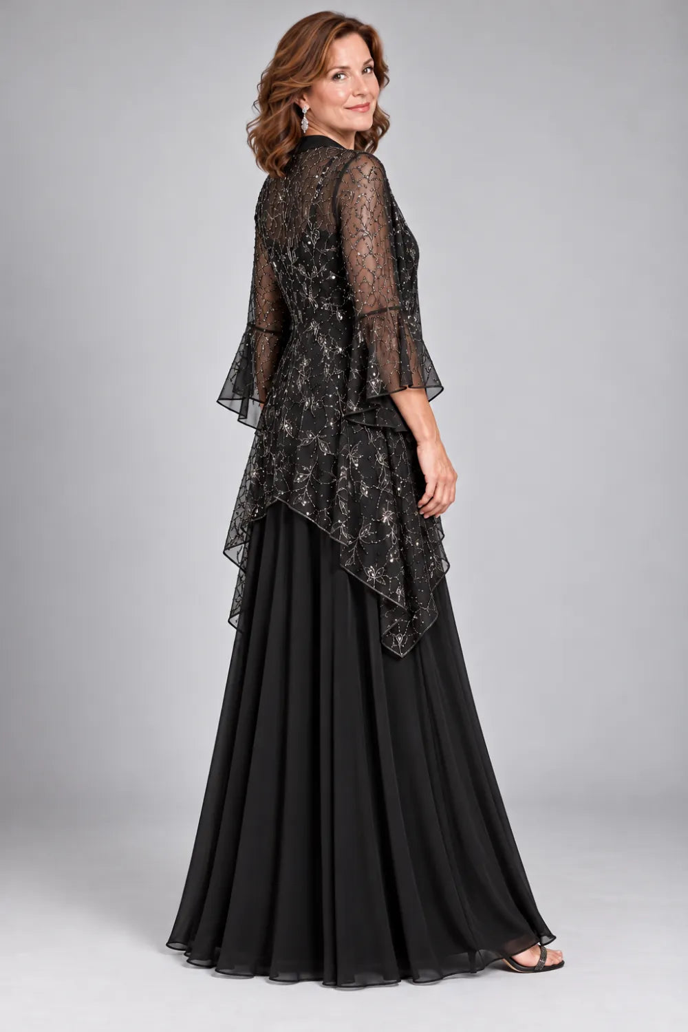 Back view of a black floor-length gown with shorter waterfall lace jacket with flared cuffs.