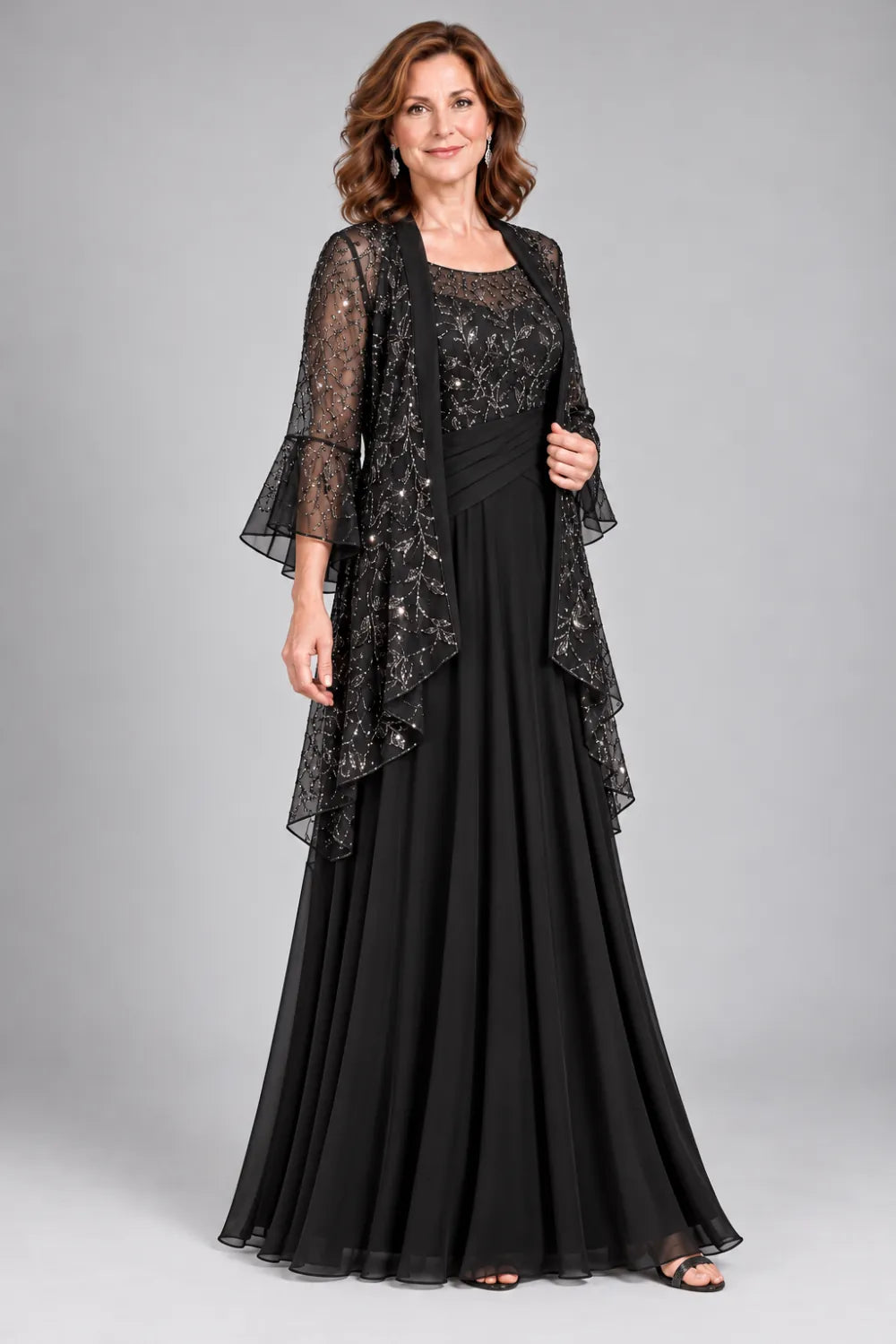 Black dress with floral decorated bodice and diagonal gathered waist, front view.