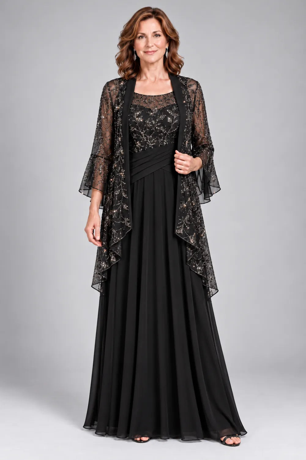 Black dress with floral decorated bodice and diagonal gathered waist, front view.