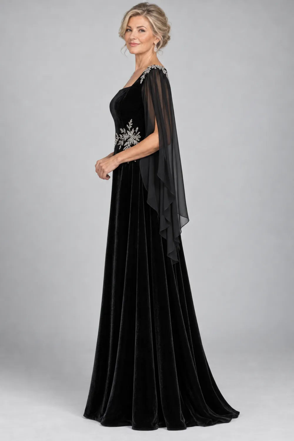 Black dress with silver-tone leafy waist and shoulder accents, side view.