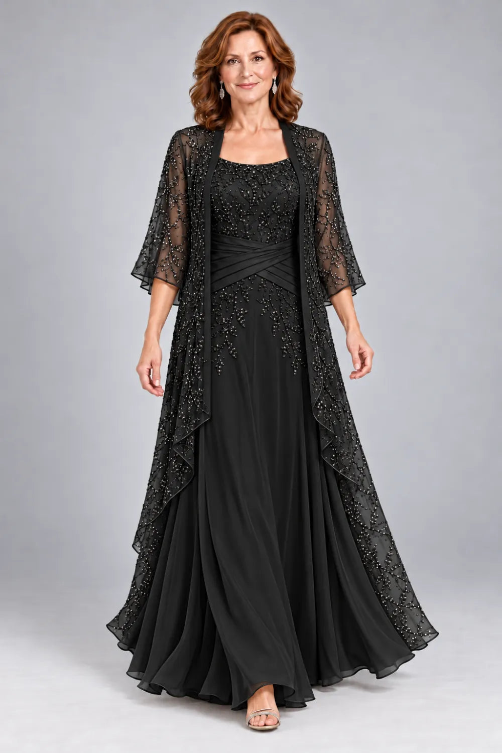 Black dress with lace bodice, diagonal waist gathers and cascading skirt panel, front view.