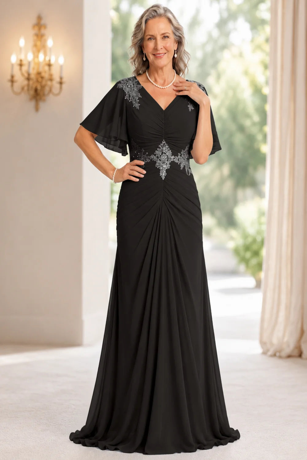 Front view of a black dress with flutter sleeves and a ruched front.