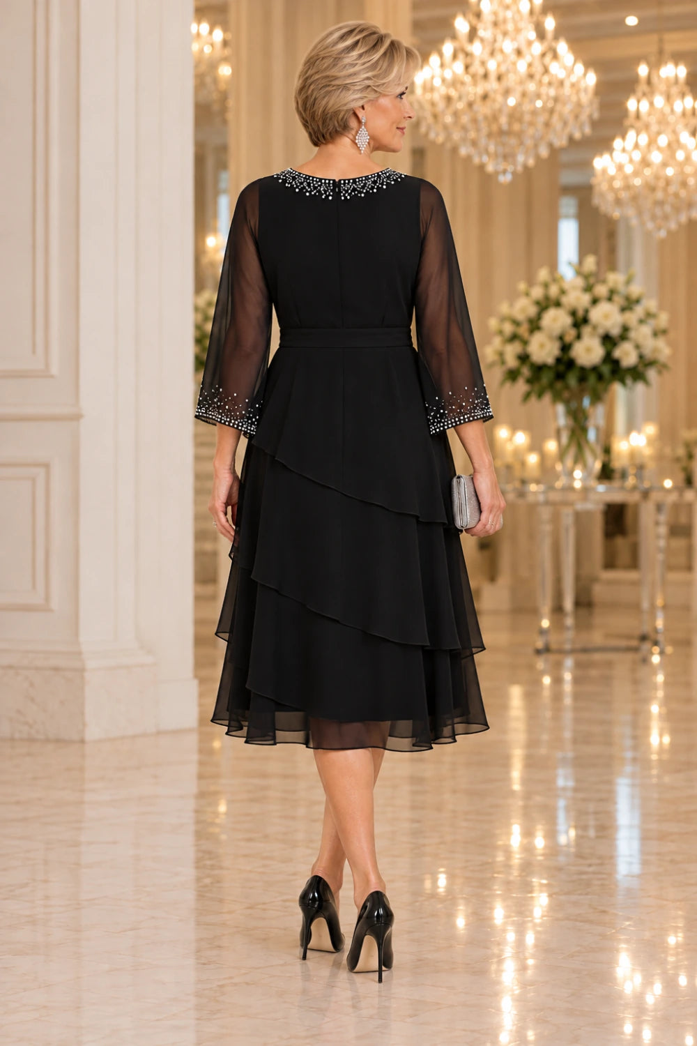 Direct back view of the black midi dress showing the rear waistband and three overlapping diagonal flounce tiers.
