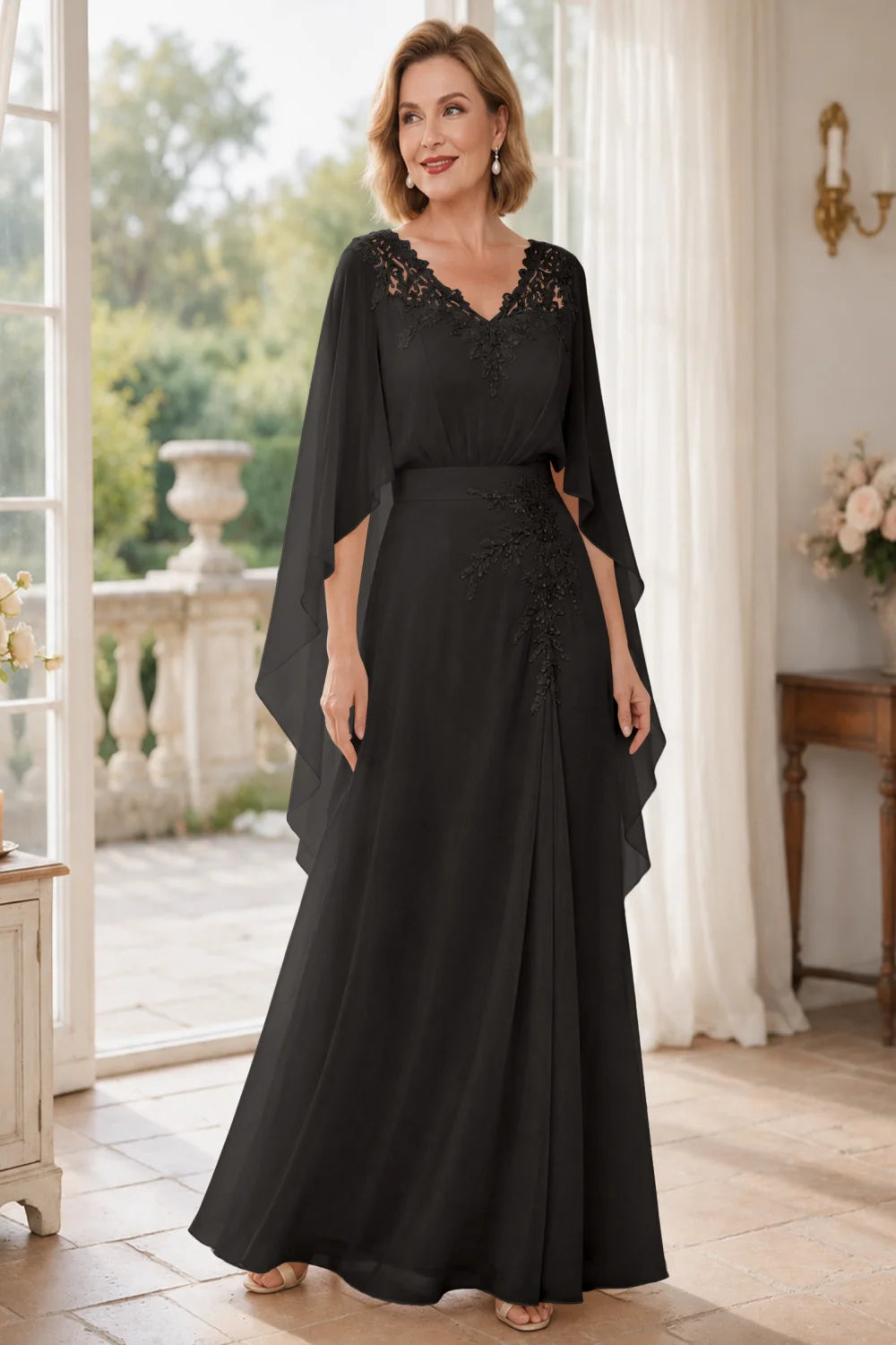Front view of a black dress with a lace V neckline and open cape panels.