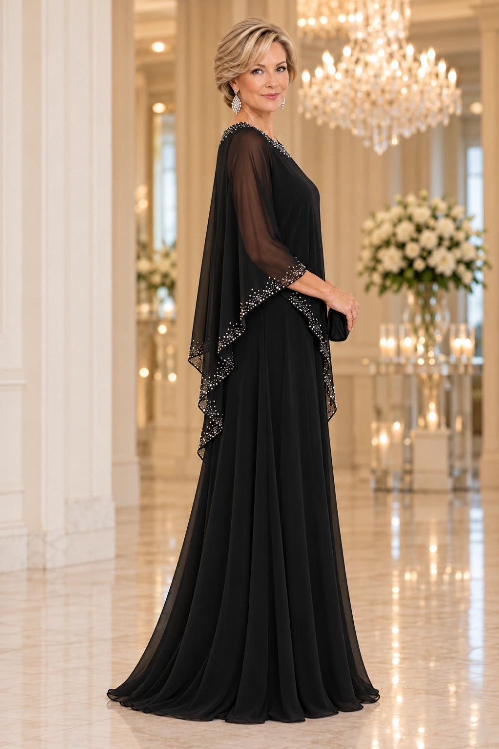 Side view of the black gown showing the cascading sheer cape edge and long skirt folds.