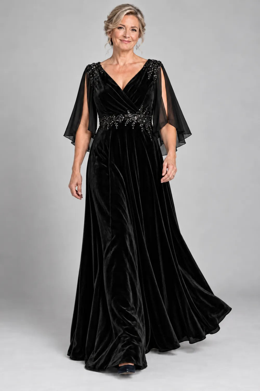 Black dress with crossover bodice and decorated waist, front view.