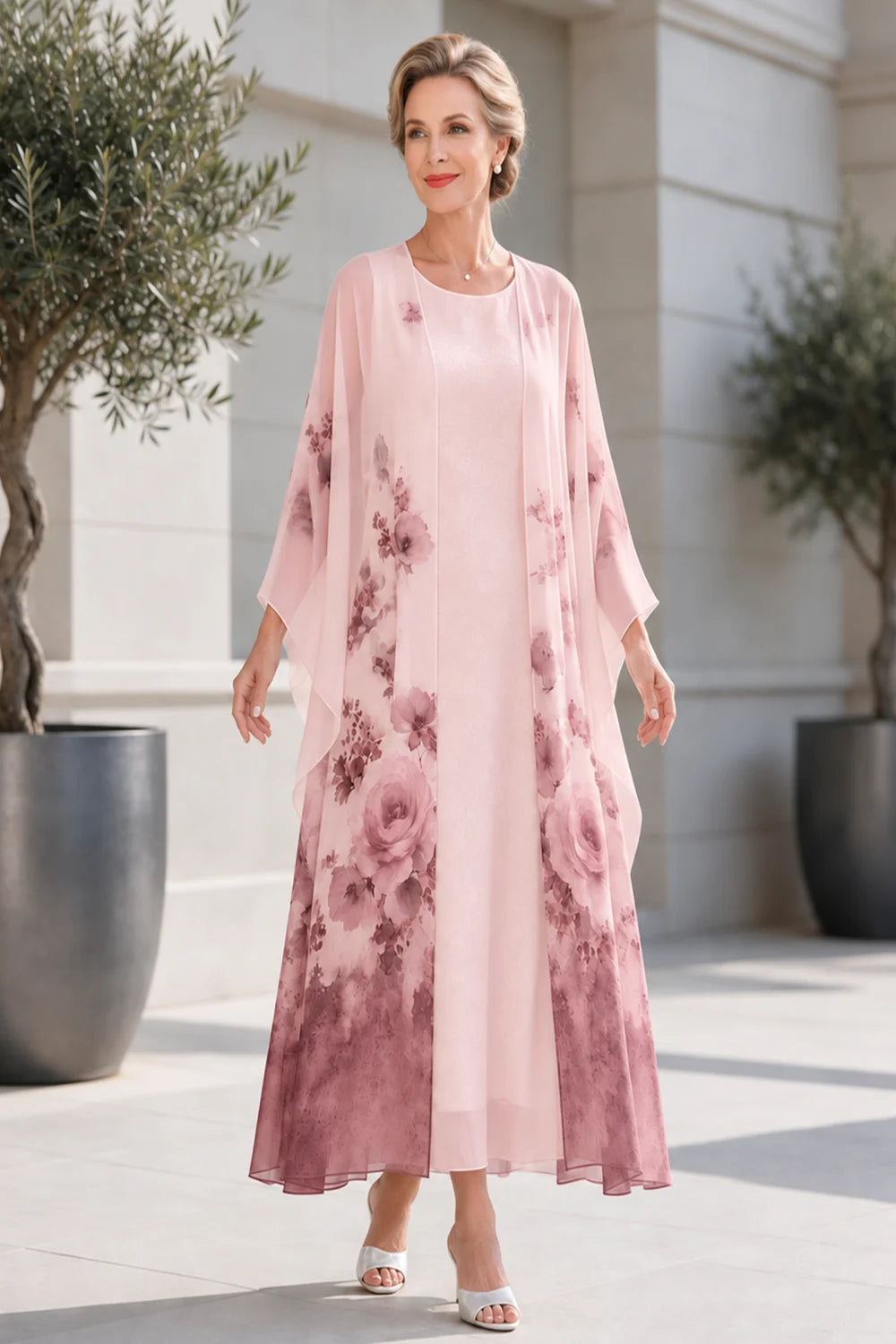 Front view of a blush pink dress with a long floral outer layer.