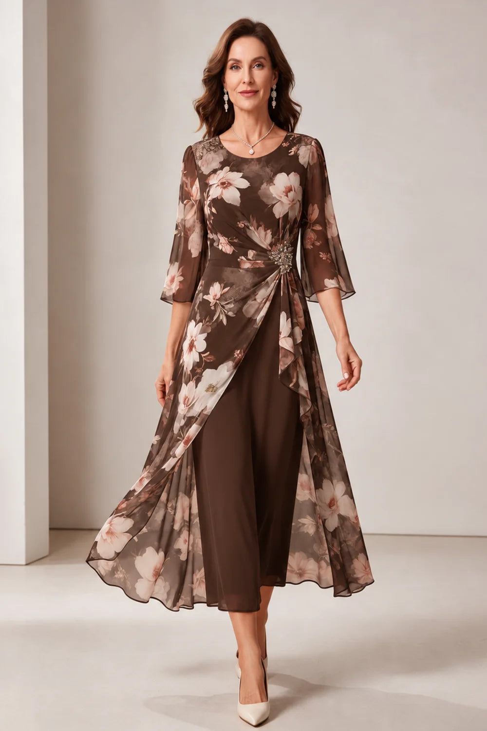 Front view of a brown dress with a floral overlay and flared sleeves.