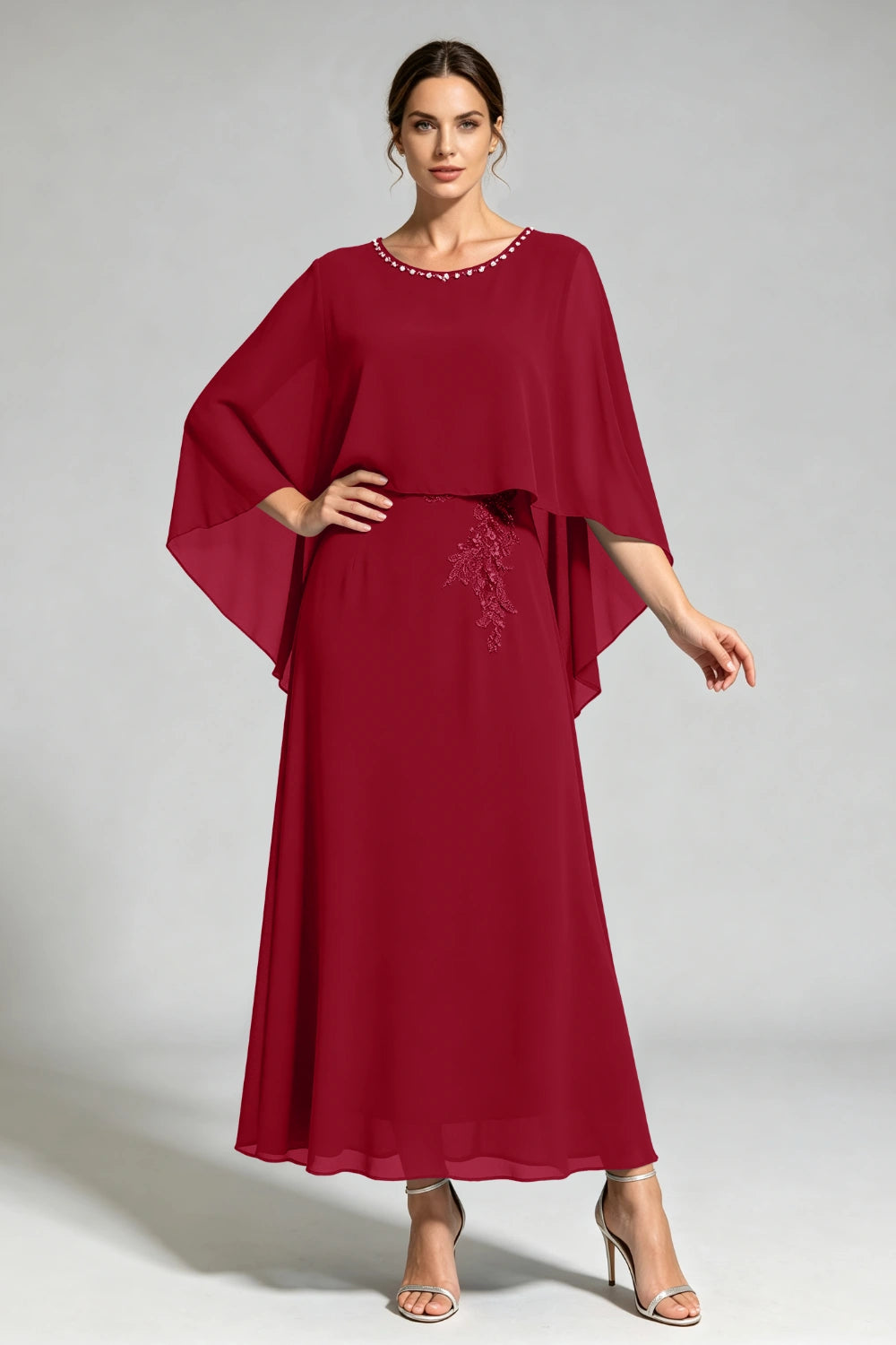 Front view of the burgundy cape dress with a beaded round neckline and tonal floral applique.