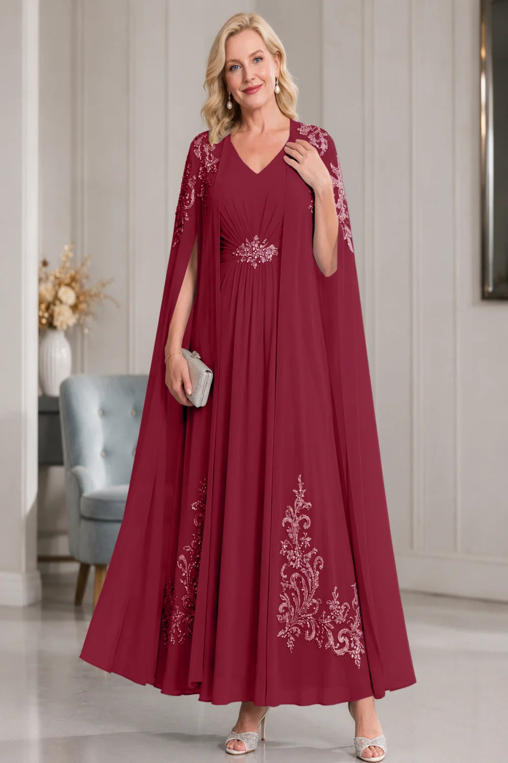 Front view of a burgundy dress with open cape panels and pale skirt motifs.
