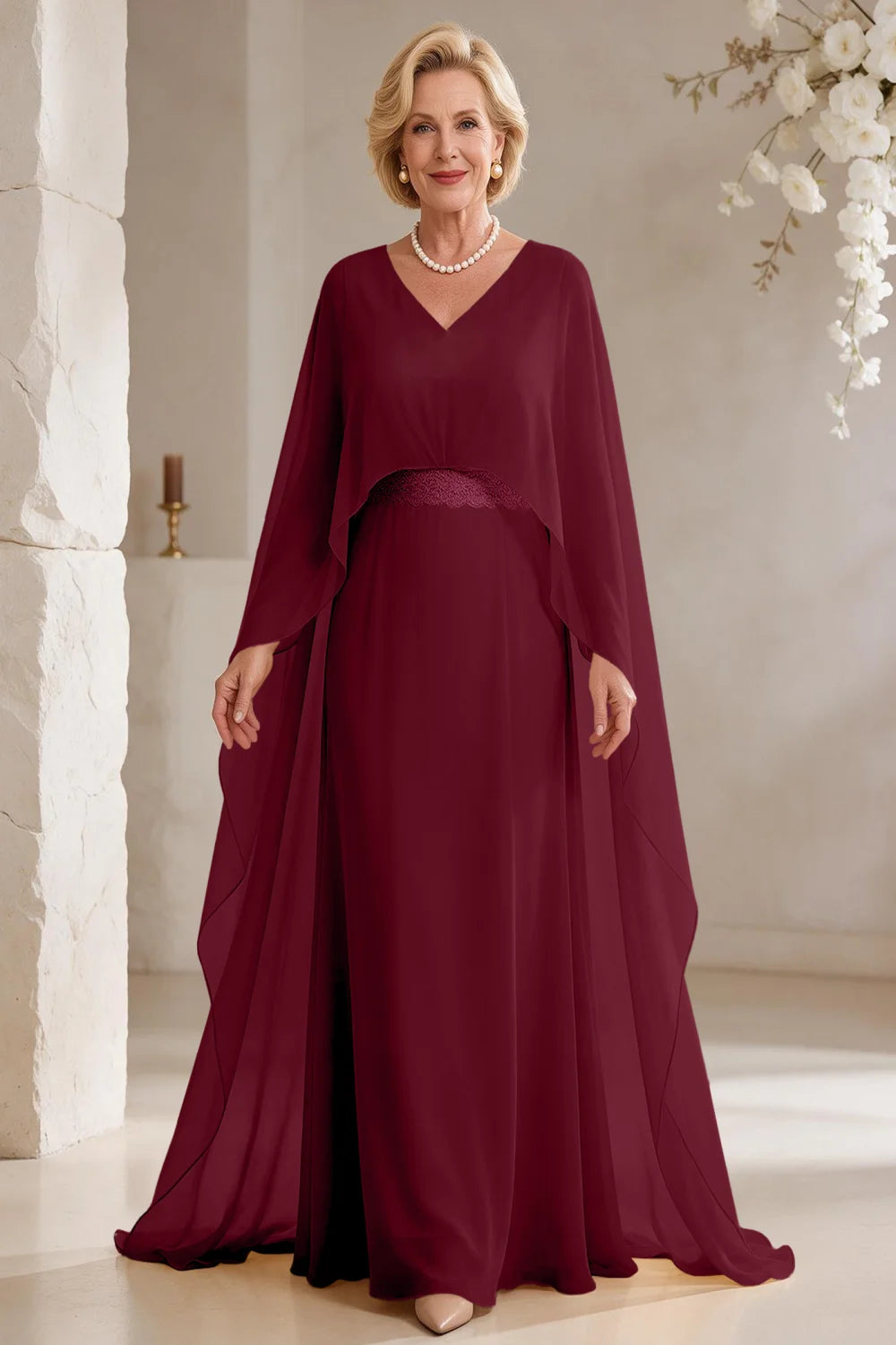 Front view of a burgundy dress with long cape panels and a flared skirt.
