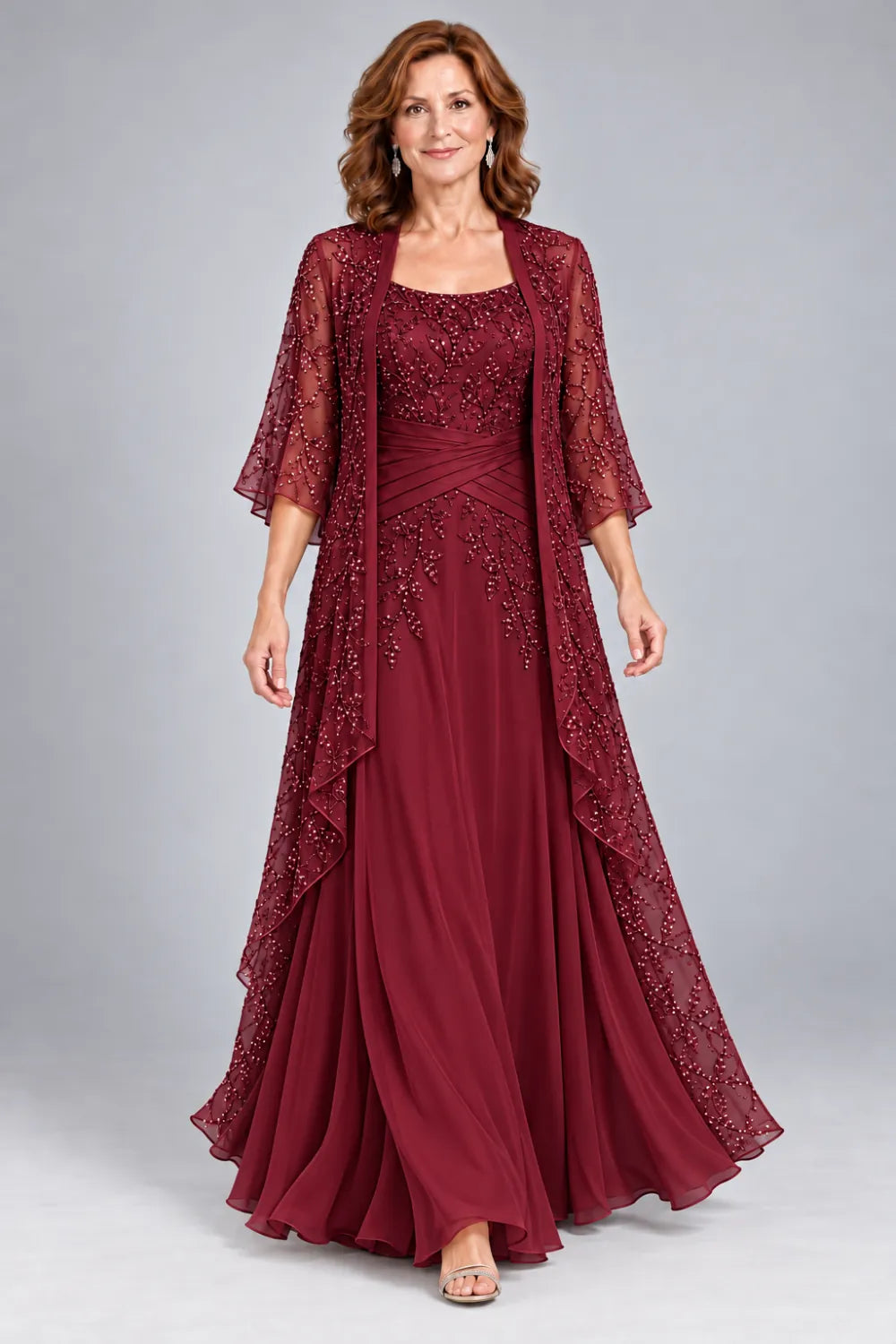 Burgundy dress with lace bodice, diagonal waist gathers and cascading skirt panel, front view.