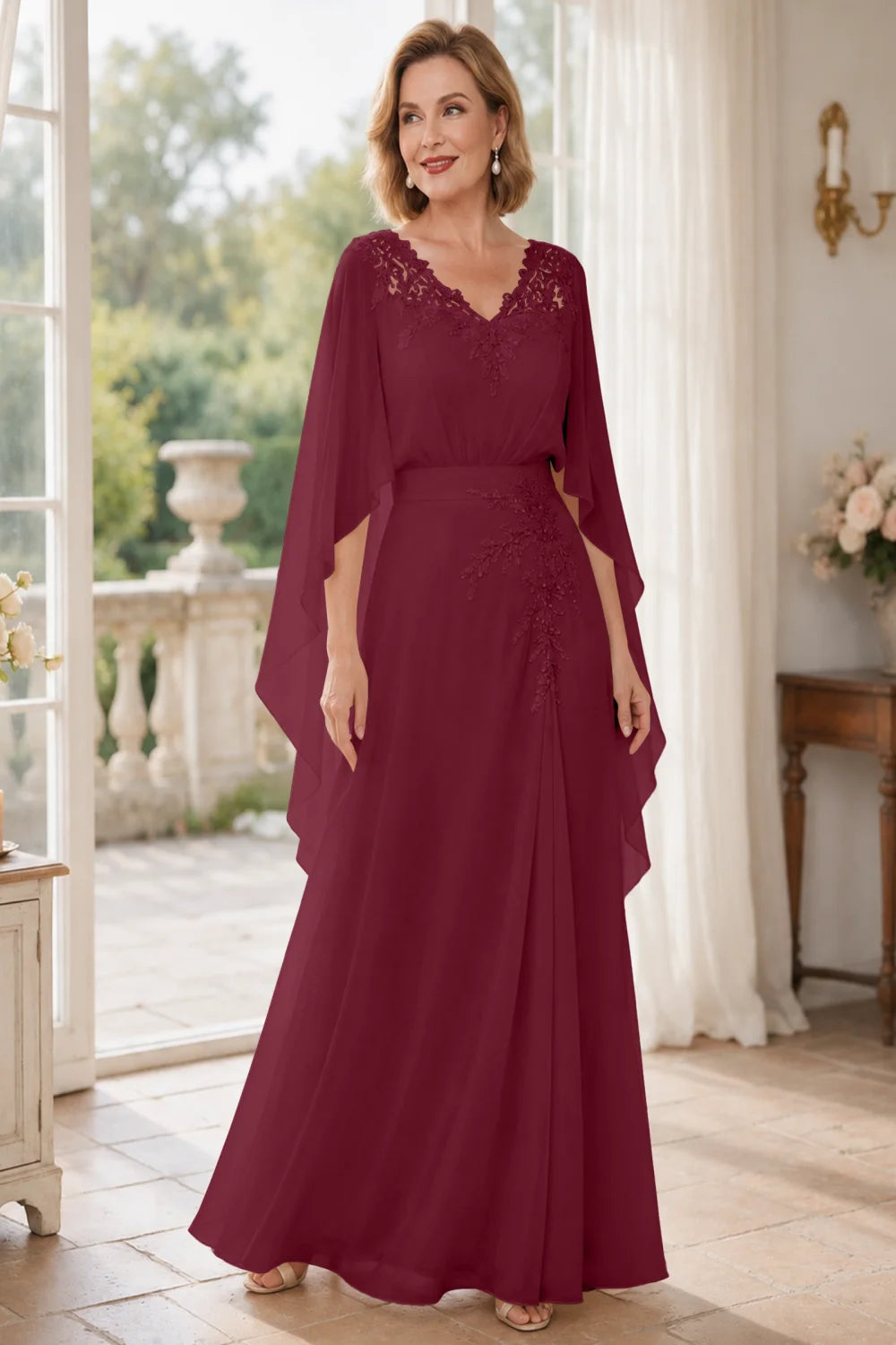 Front view of a burgundy dress with a lace V neckline and open cape panels.