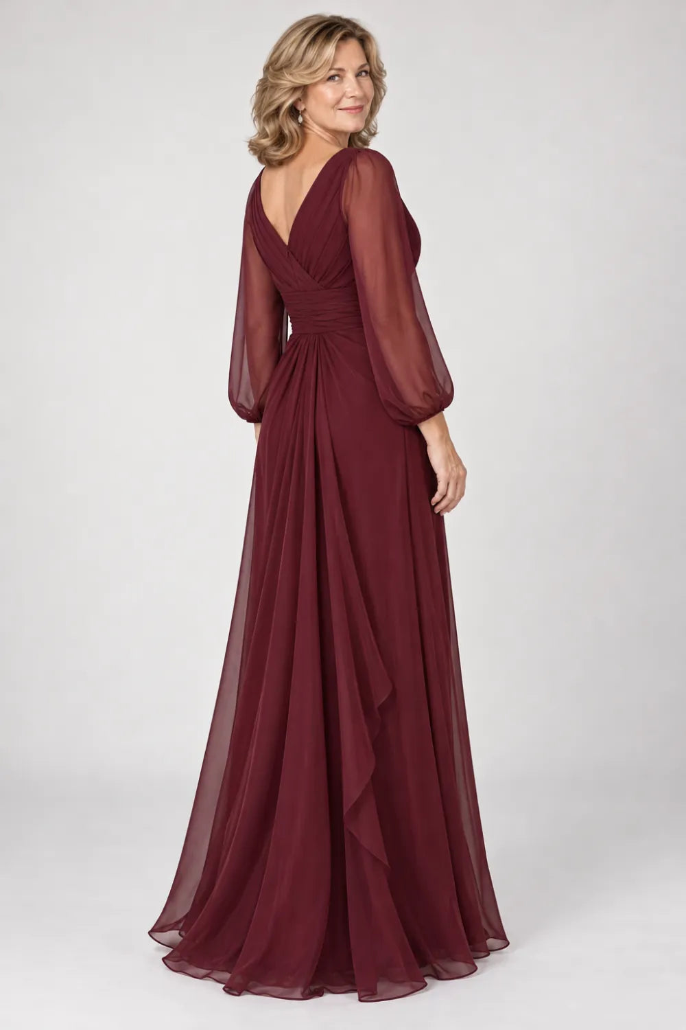 Back view of a burgundy floor-length gown with long sheer bishop sleeves with gathered cuffs.