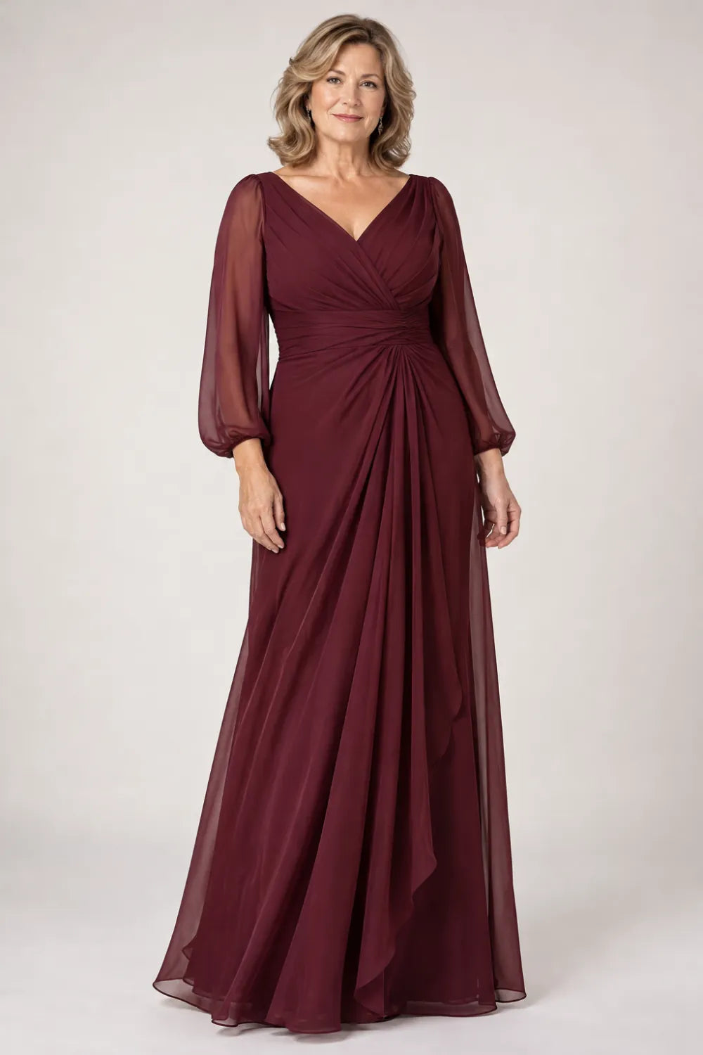 Burgundy dress with crossover bodice, gathered waist and cascading side panel, front view.