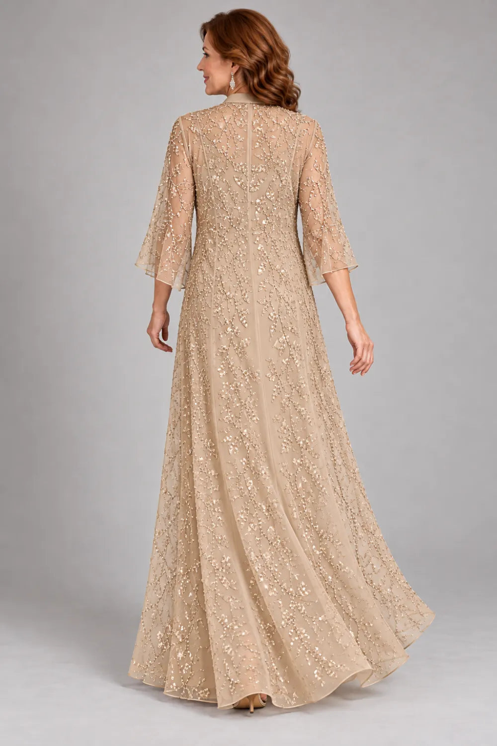 Back view of a champagne floor-length gown with almost floor-length open lace coat with flared cuffs.