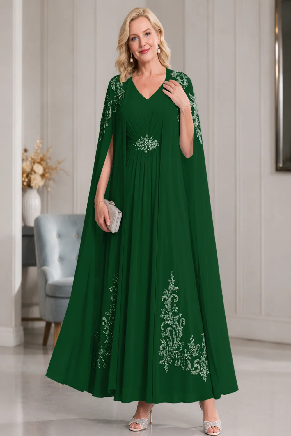 Front view of a dark green dress with open cape panels and pale skirt motifs.
