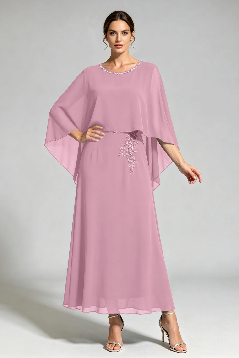 Front view of the dusty rose cape dress with a beaded round neckline and tonal floral applique.