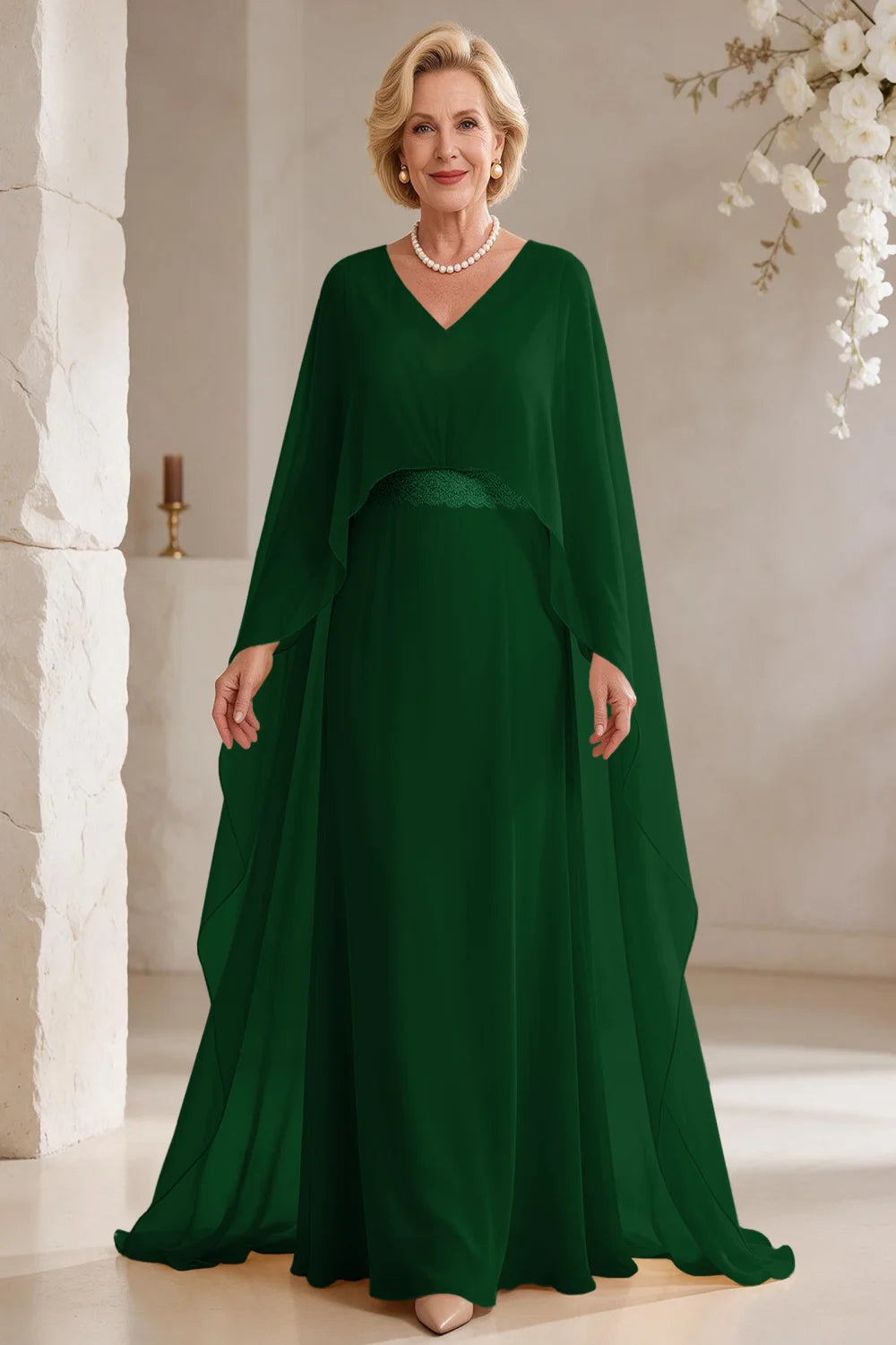 Front view of a emerald green dress with long cape panels and a flared skirt.