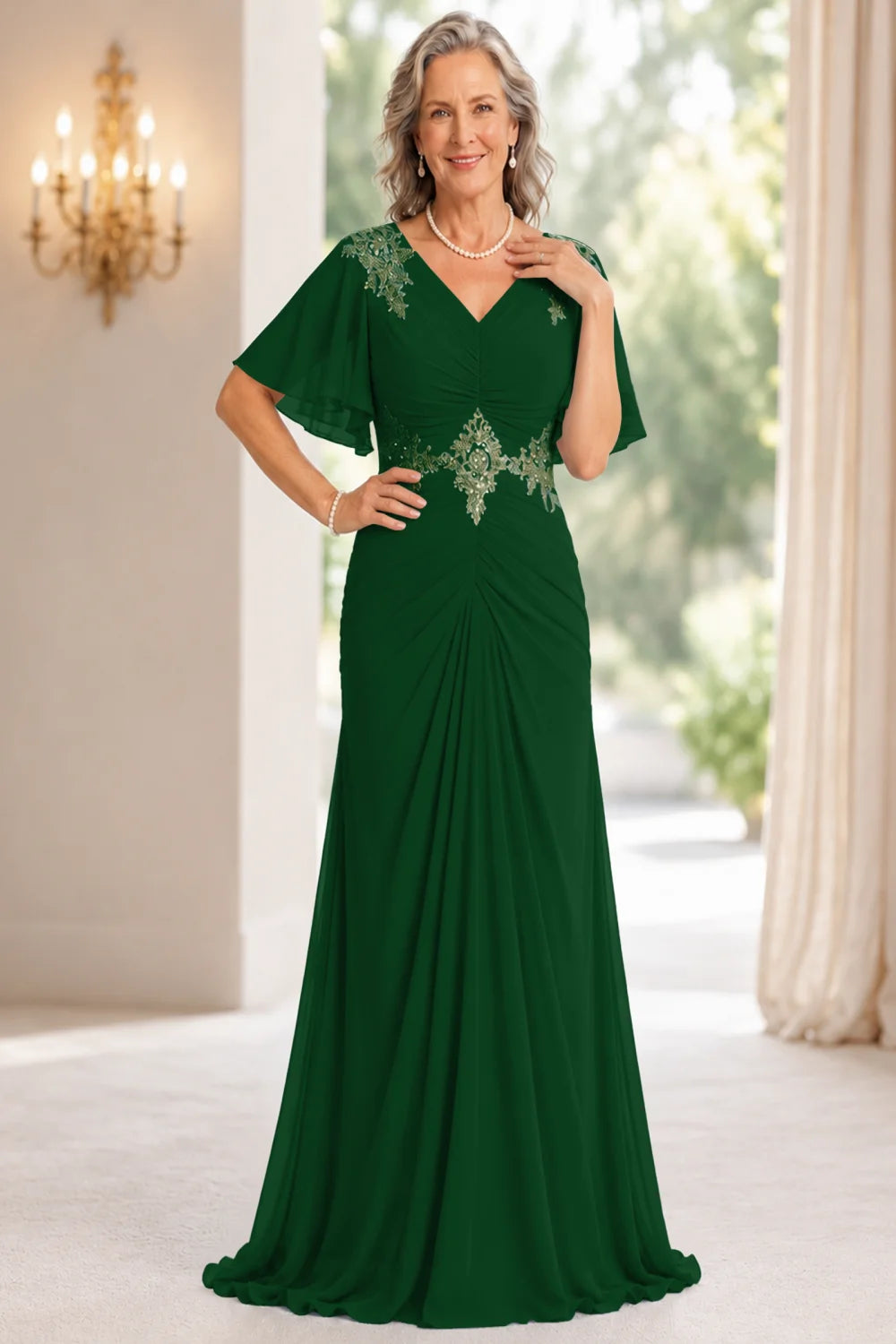 Front view of a emerald green dress with flutter sleeves and a ruched front.