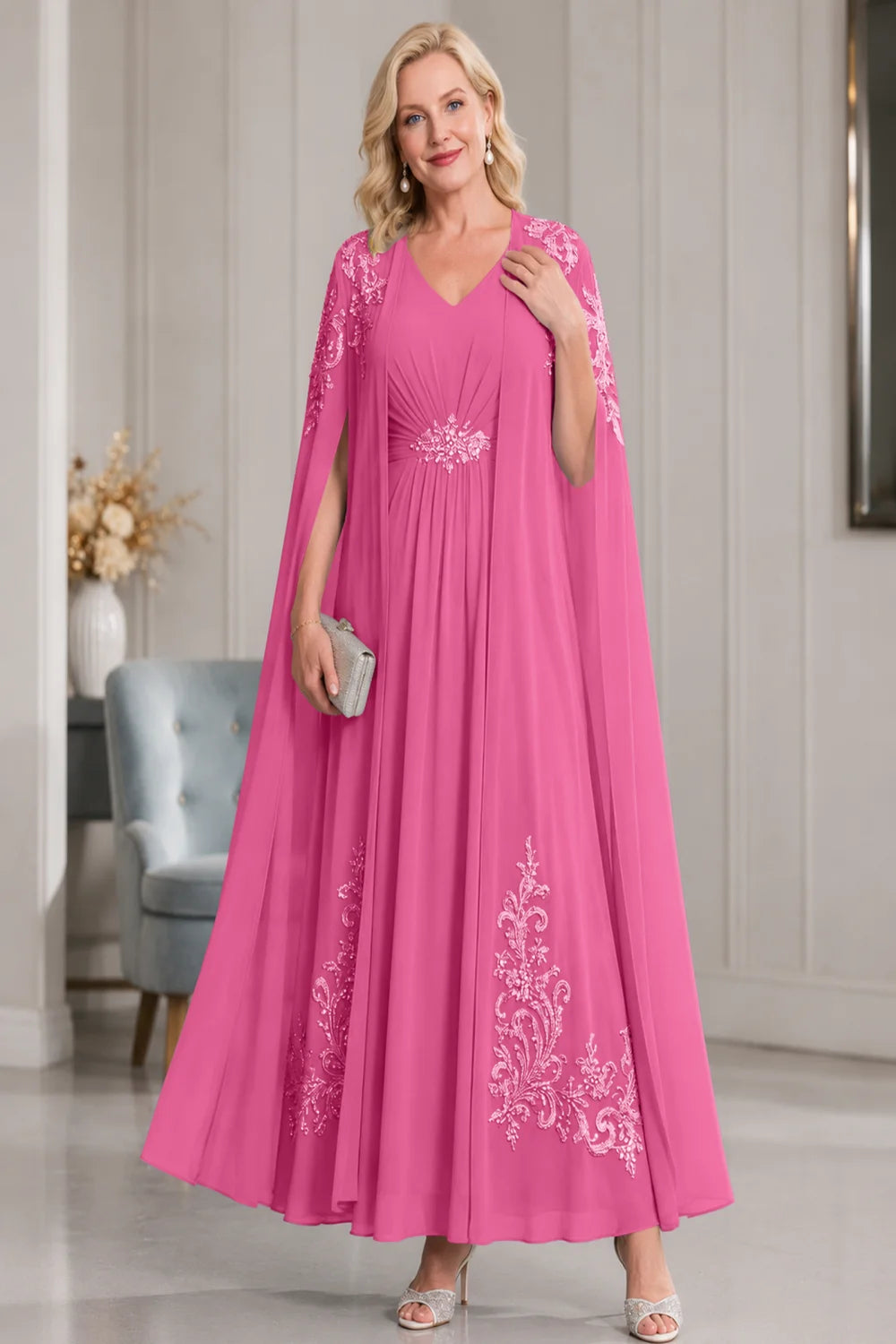 Front view of a hot pink dress with open cape panels and pale skirt motifs.