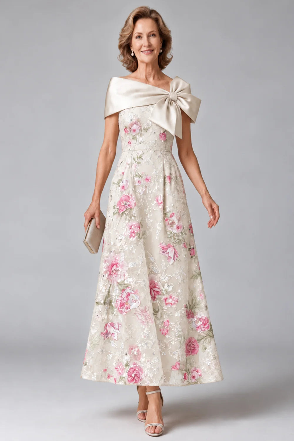 Front view of a ivory dress with a broad neckline bow and floral skirt.