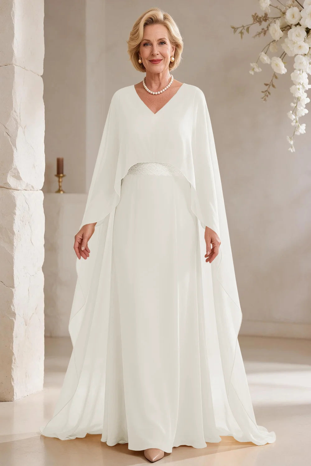 Front view of a ivory dress with long cape panels and a flared skirt.