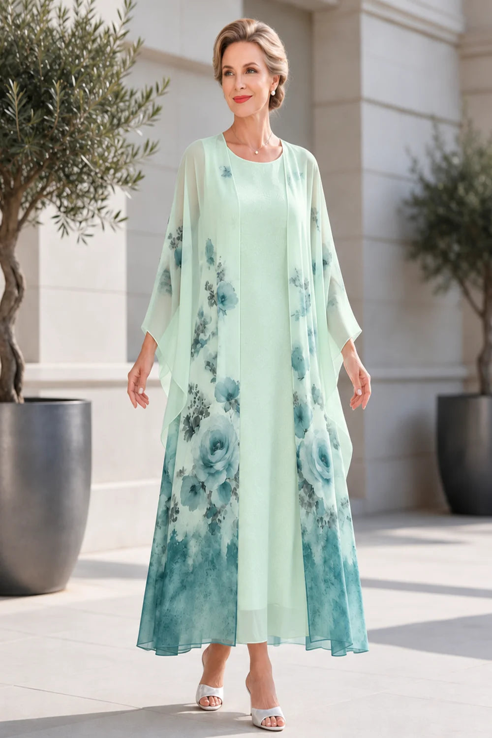 Front view of a mint green dress with a long floral outer layer.