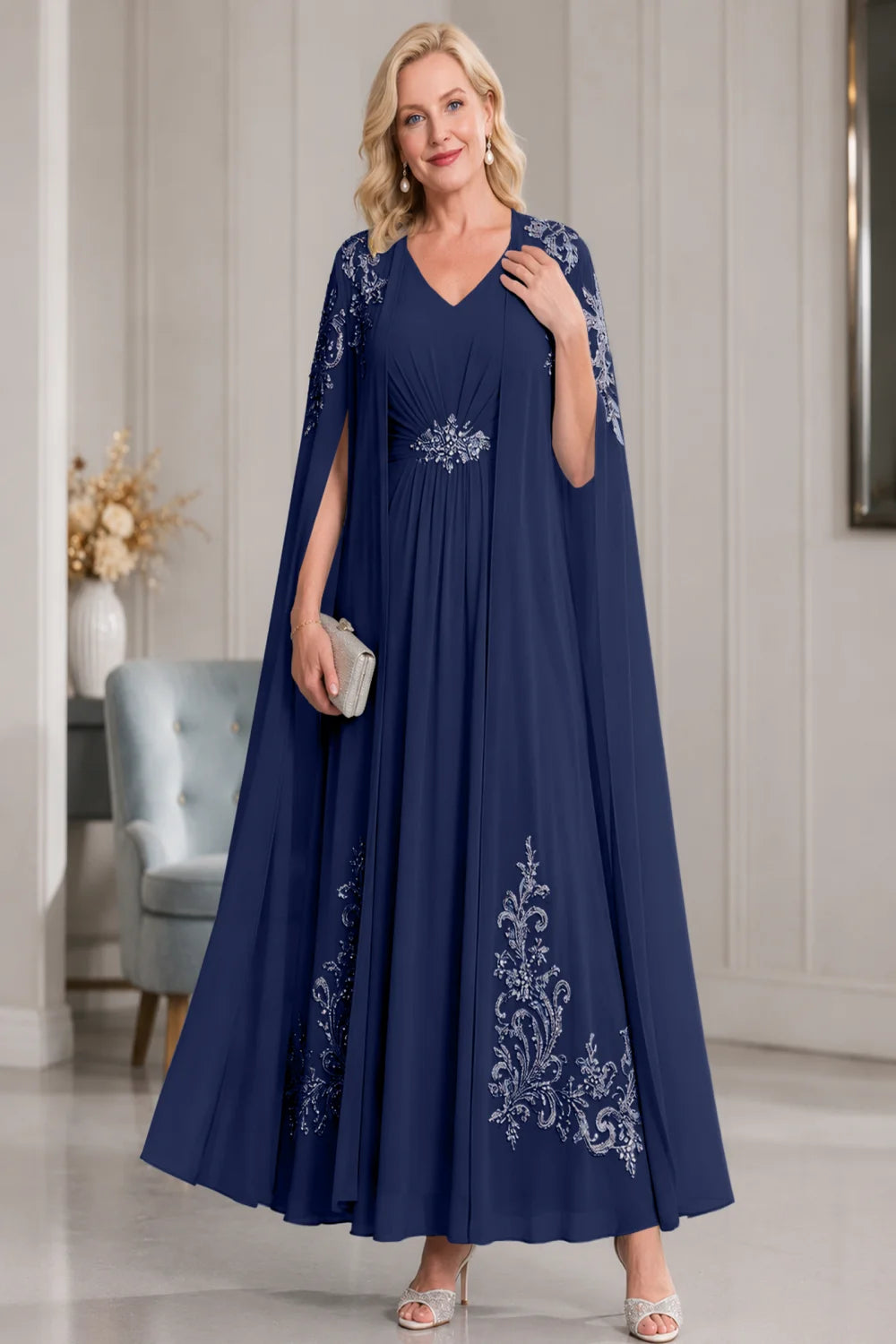 Front view of a navy blue dress with open cape panels and pale skirt motifs.