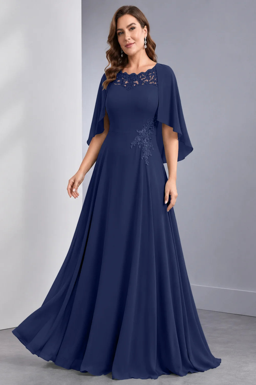 Front view of a navy blue dress with draped sleeve panels and a lace neckline.