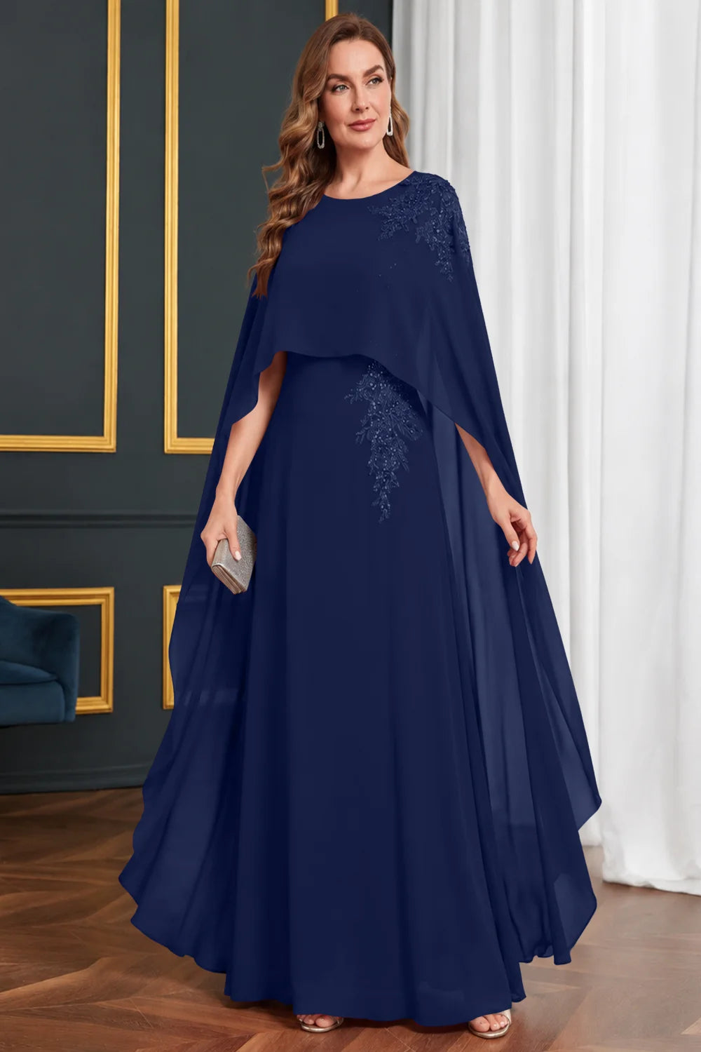 Front view of a navy blue dress with long cape panels and shoulder decoration.