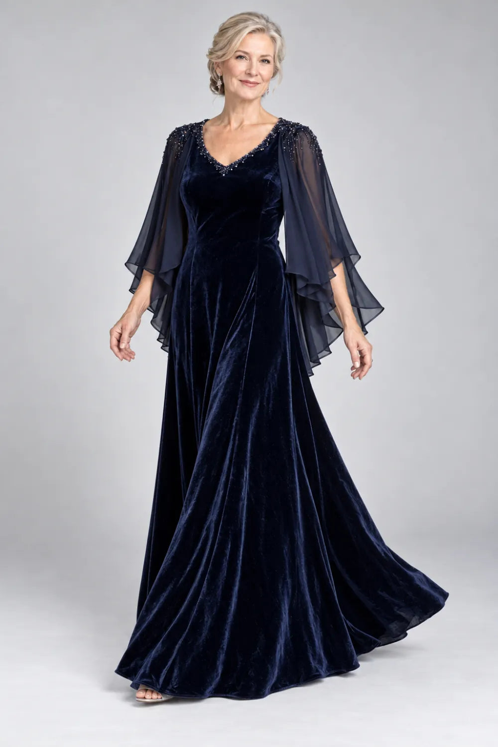 Navy Blue dress with beaded v-neck and layered cascading cape, posed front view.