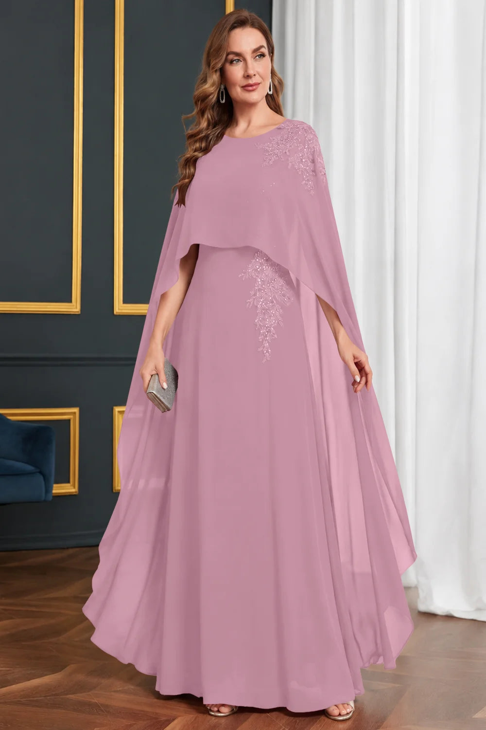 Front view of a pink dress with long cape panels and shoulder decoration.
