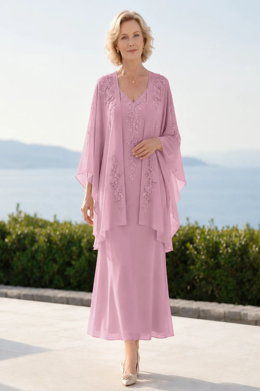 Front view of a pink dress with a decorated neckline and long upper overlay.