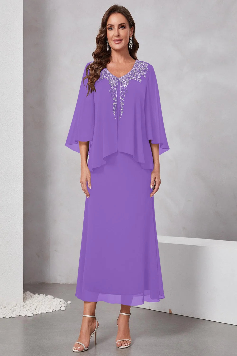 Front view of a purple dress with a decorated neckline and short upper overlay.