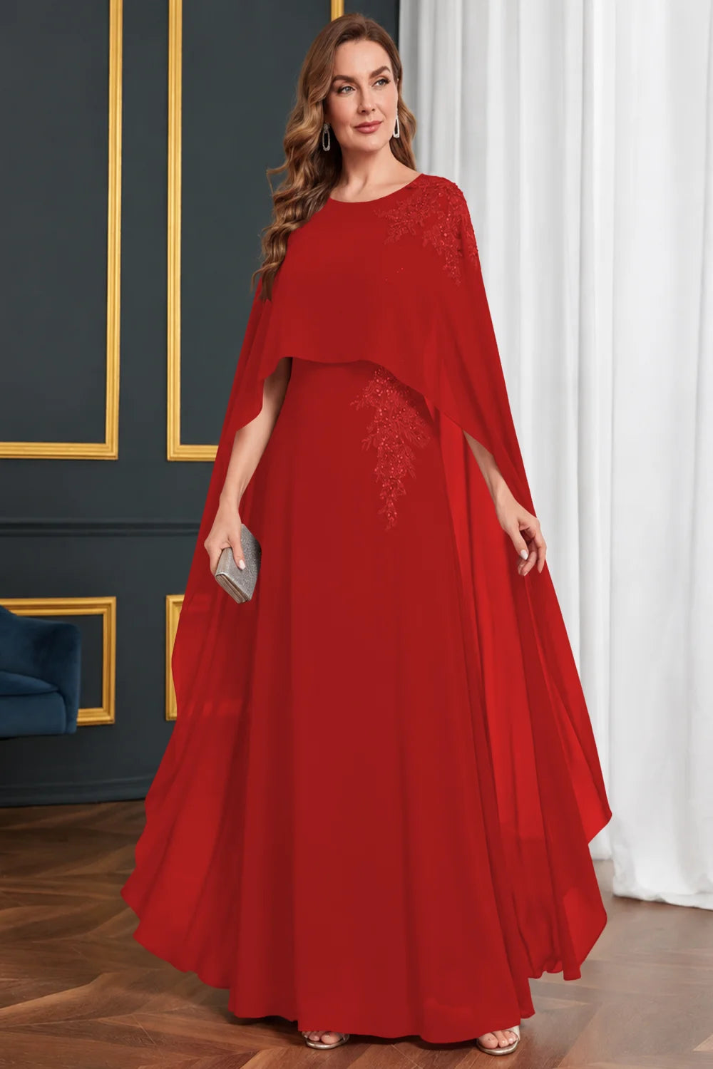 Front view of a red dress with long cape panels and shoulder decoration.