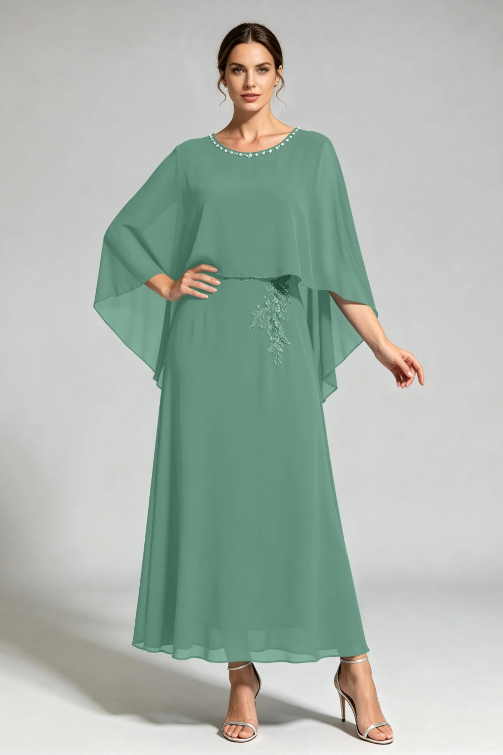 Front view of the sage green cape dress with a beaded round neckline and tonal floral applique.