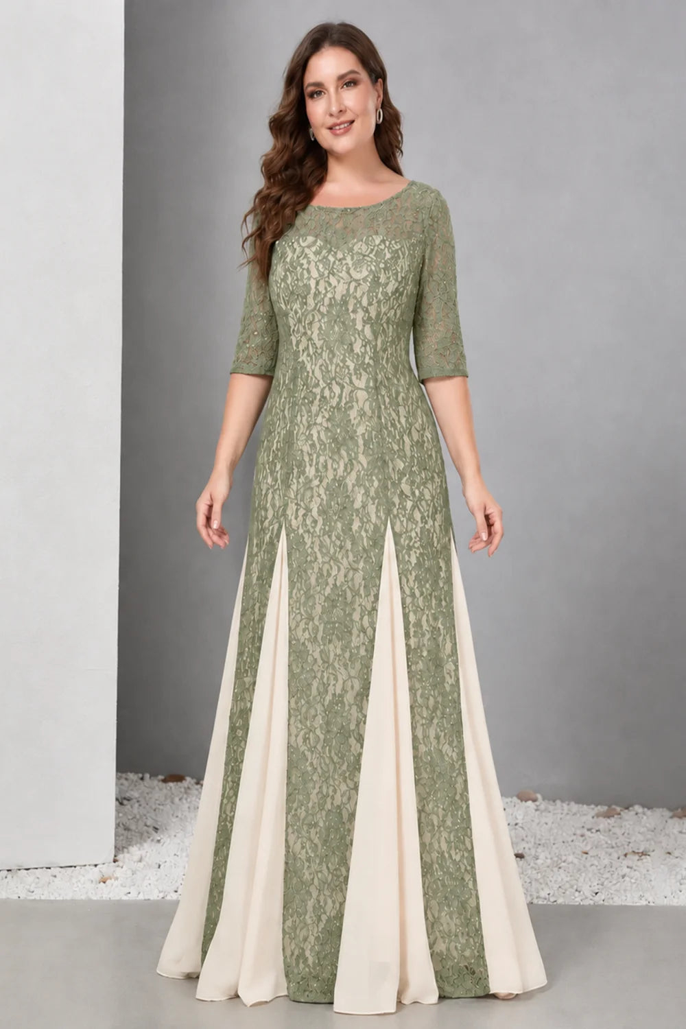 Front view of a sage green dress with lace and contrasting pale skirt panels.