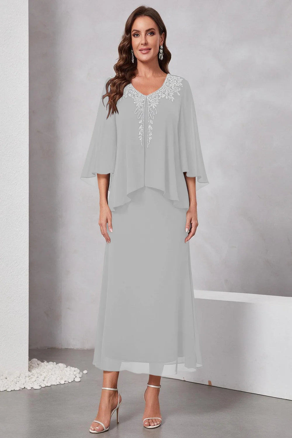 Front view of a silver gray dress with a decorated neckline and short upper overlay.