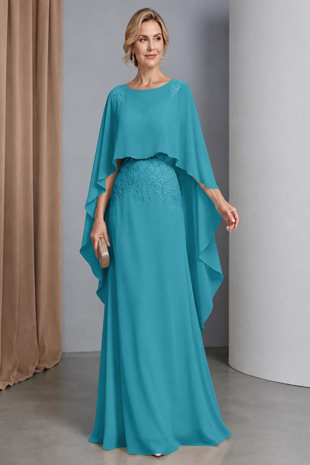 Front view of a teal dress with a curved cape front and embellished waist.
