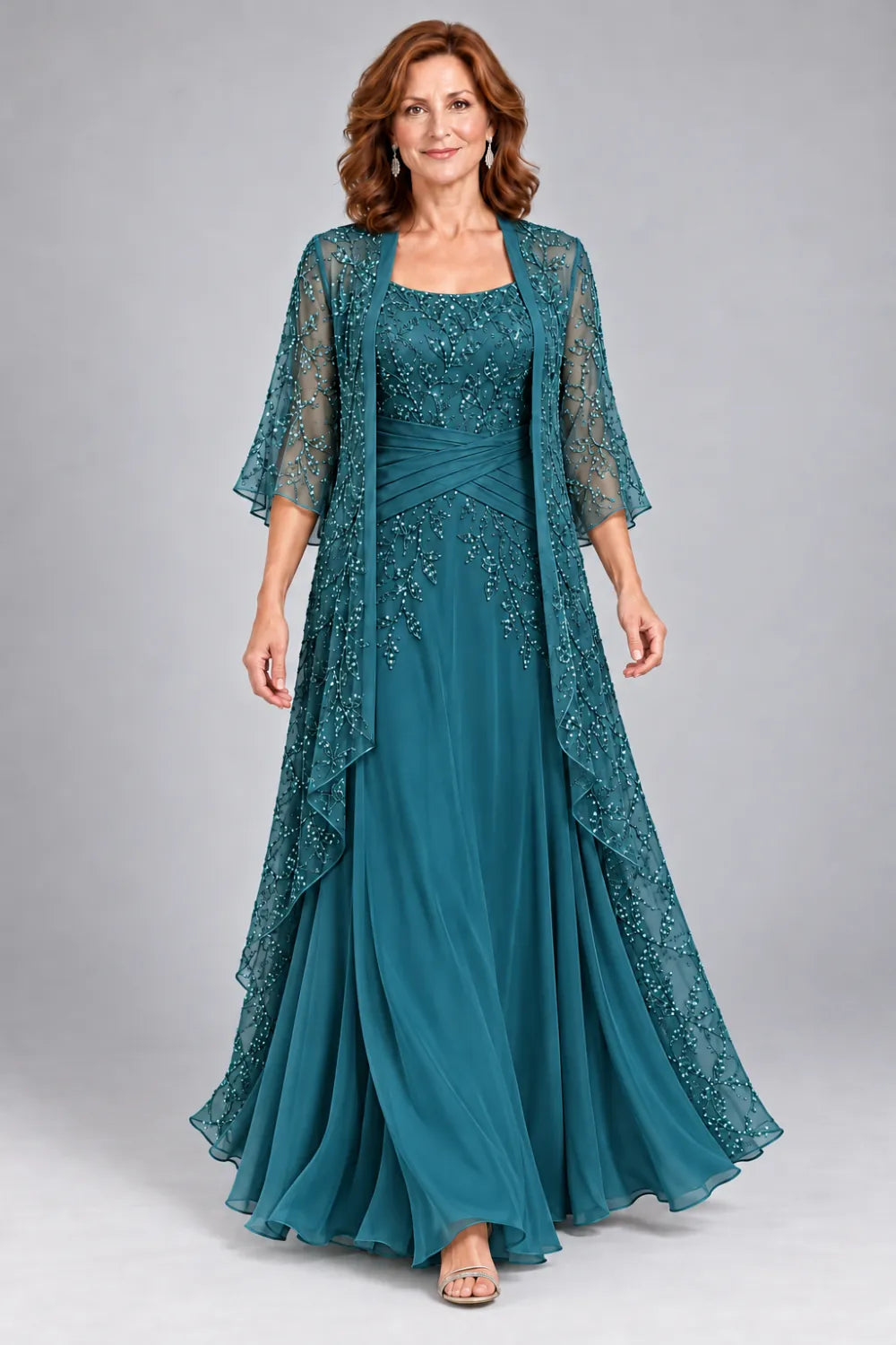 Teal dress with lace bodice, diagonal waist gathers and cascading skirt panel, front view.