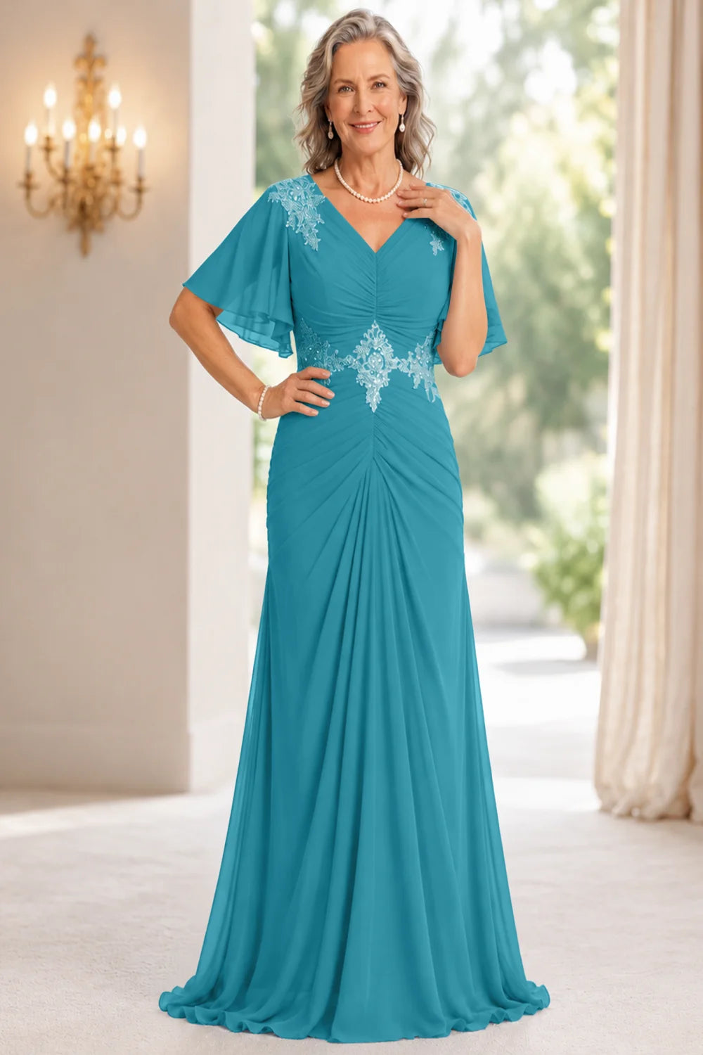 Front view of a teal dress with flutter sleeves and a ruched front.