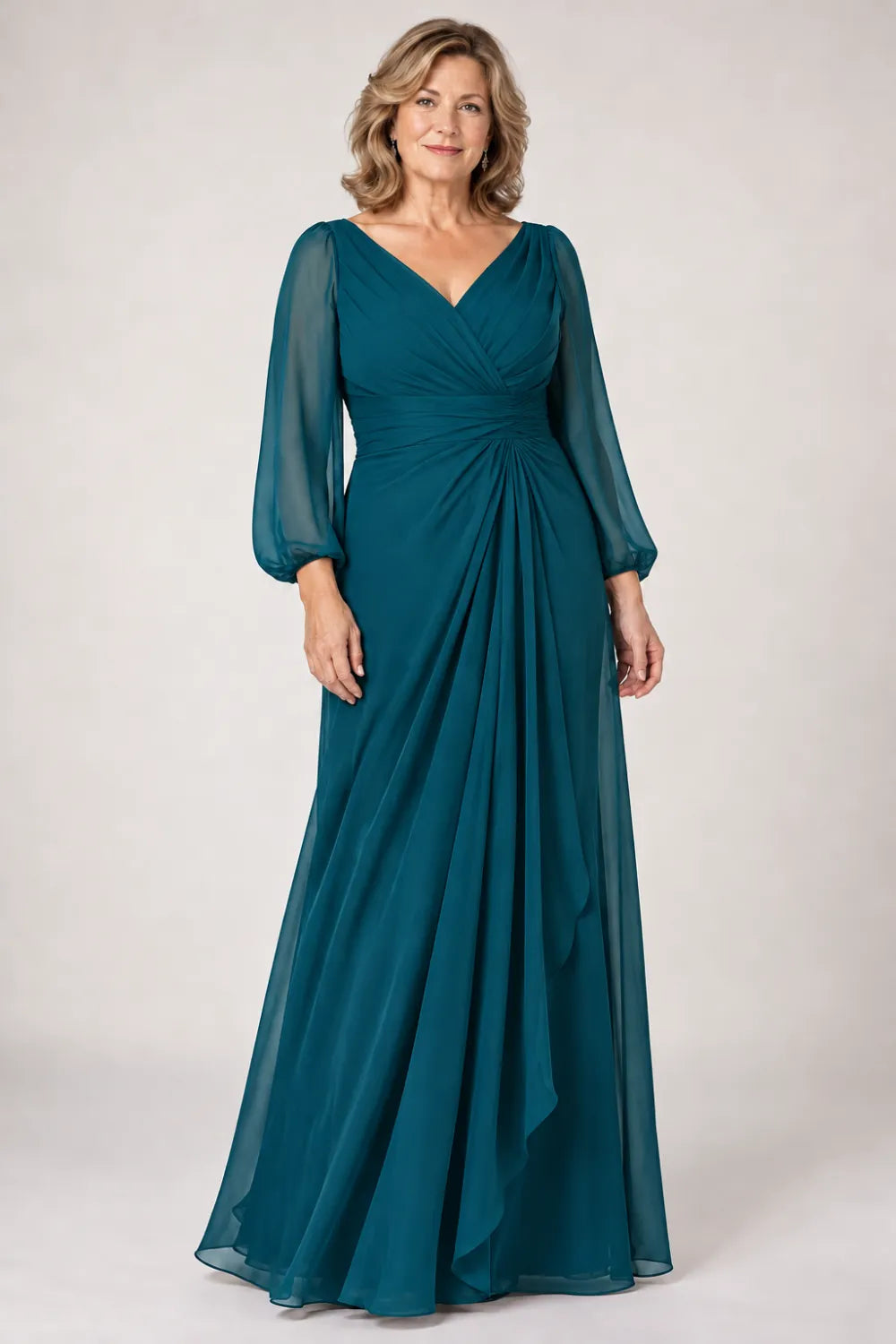 Teal dress with crossover bodice, gathered waist and cascading side panel, front view.