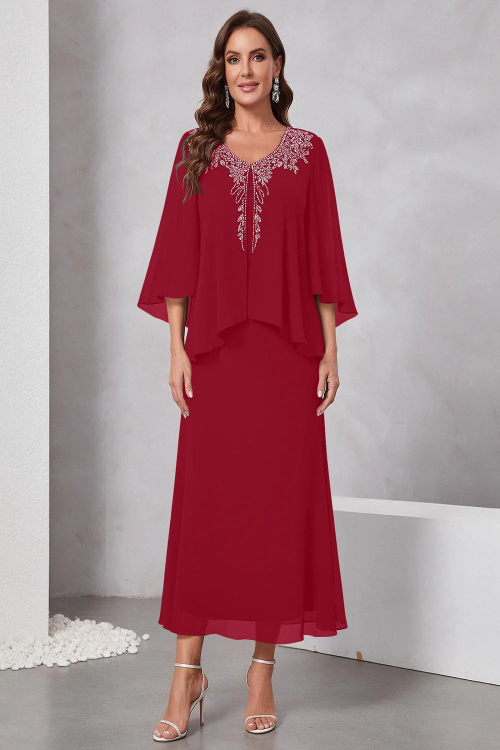 Front view of a wine red dress with a decorated neckline and short upper overlay.