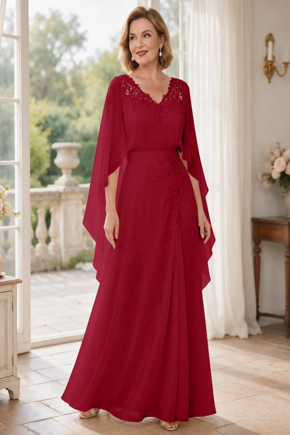 Front view of a wine red dress with a lace V neckline and open cape panels.