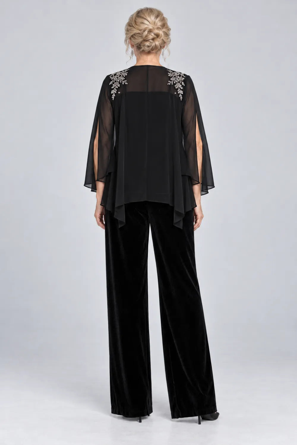 Back view of a black wide-leg pant suit with open-front sheer split-sleeve cape jacket.