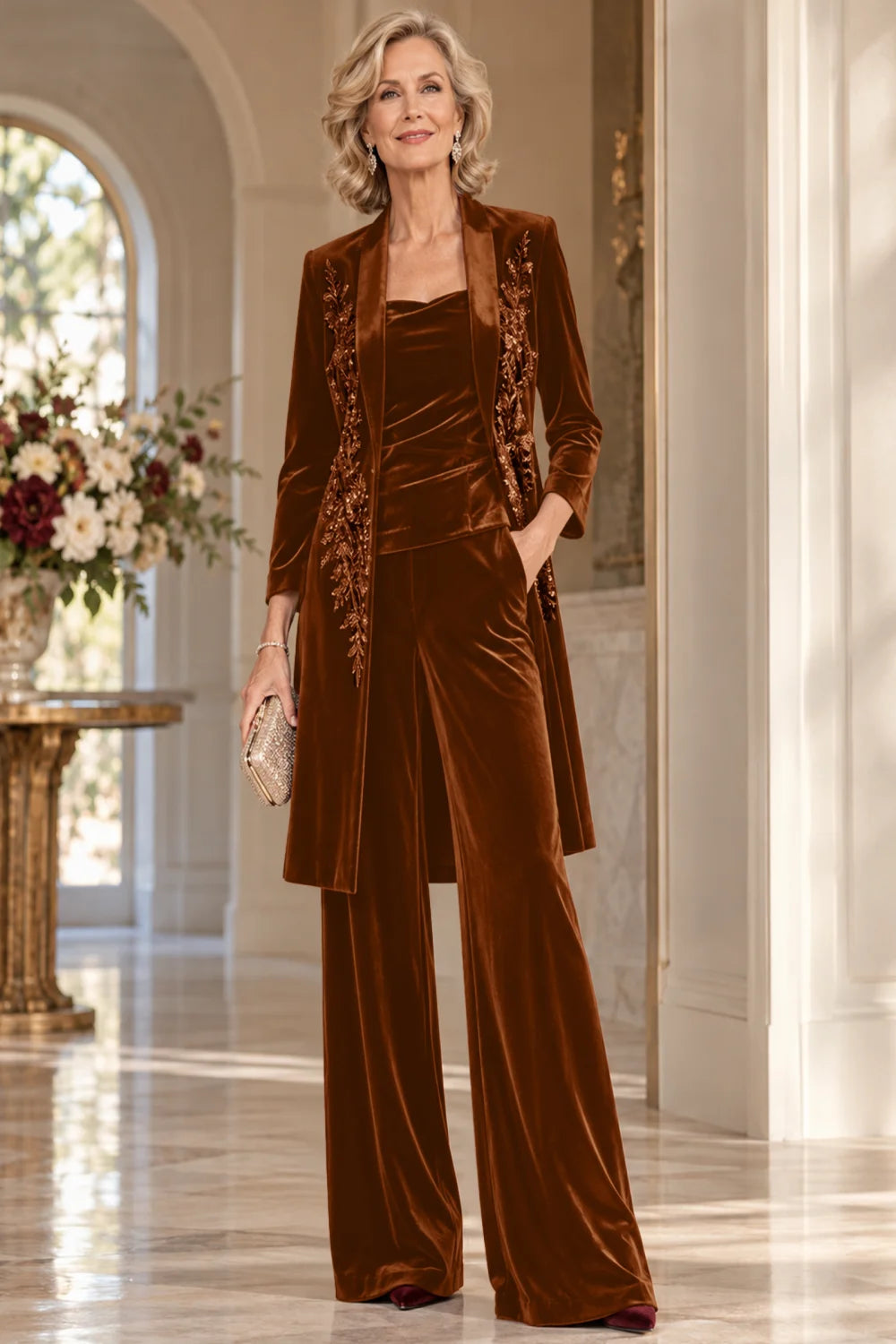Front view of a brown pant suit with a floral-trimmed long jacket and wide-leg trousers.