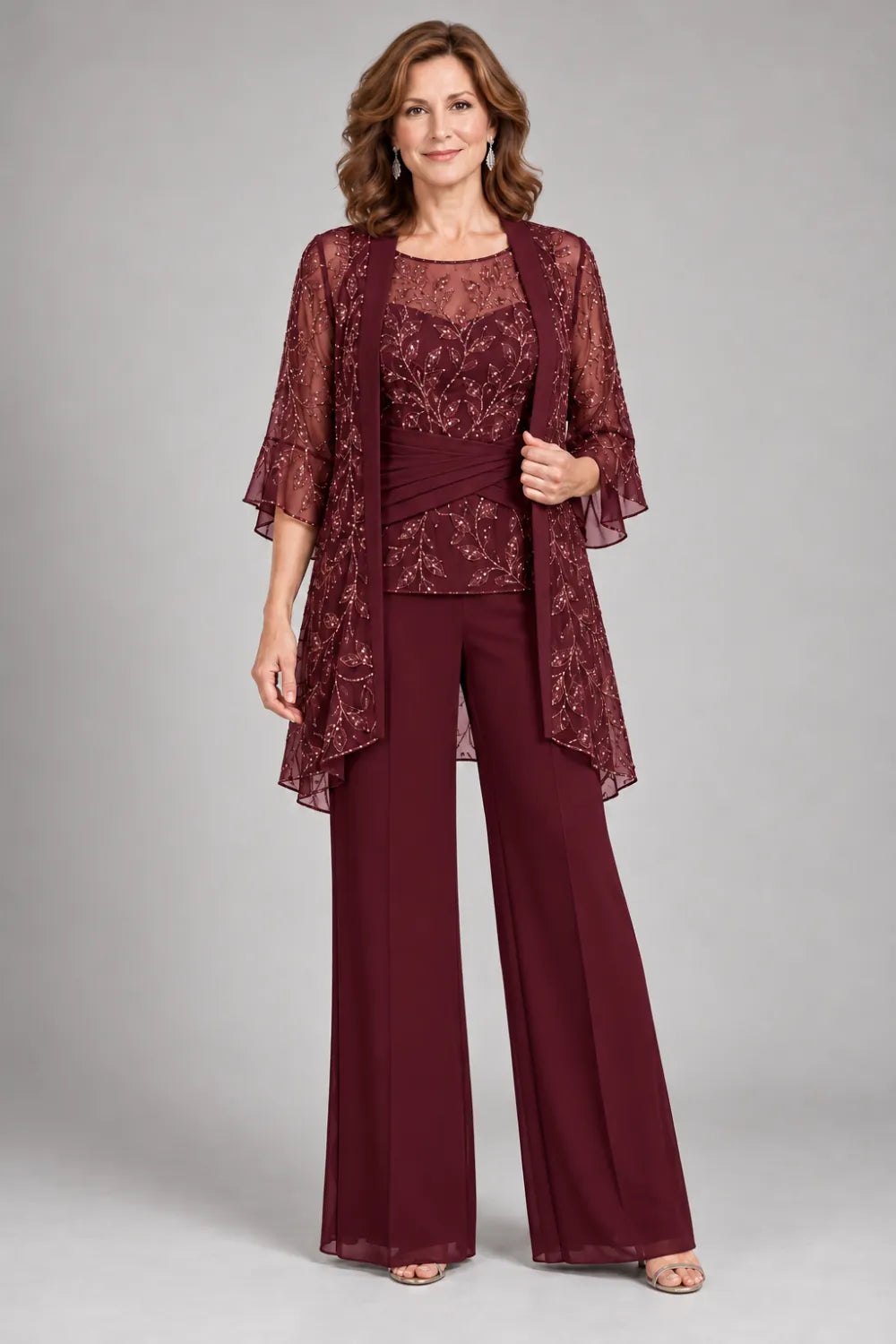 Burgundy pant suit with floral lace top and diagonal gathered waist, front view.
