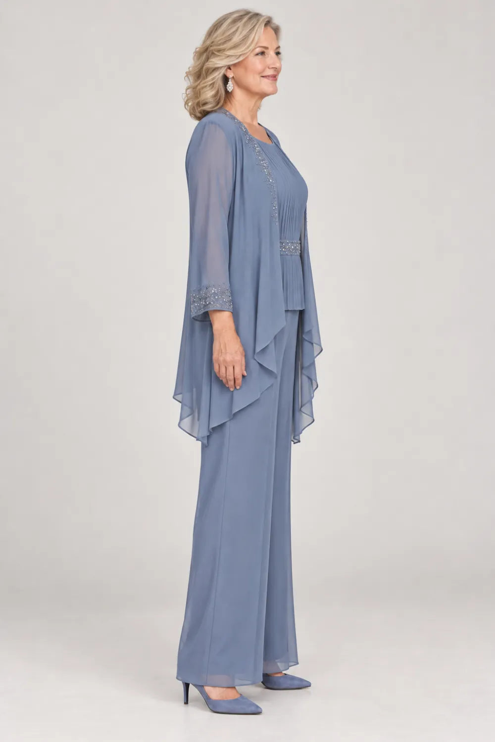 Dusty Blue pant suit with pleated top and beaded waist, jacket edges and cuffs, side view.